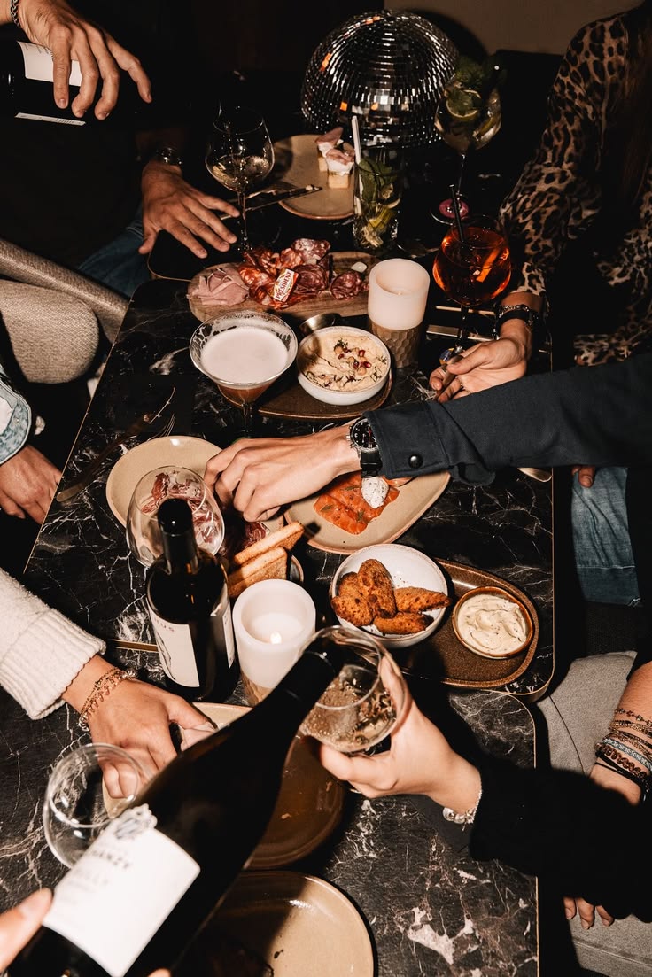 Overhead view of an intimate dinner table with wine, candles, and shared plates